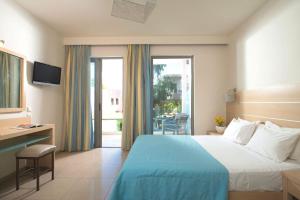 een hotelkamer met een bed, een bureau en een raam bij Corissia Beach hotel in Georgioupolis