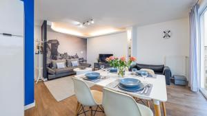 a dining room and living room with a table and chairs at Apartamenty Sun&Snow Marina Primore in Gdańsk