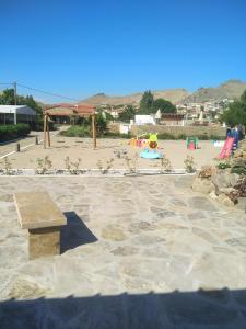 a park with a bench in front of a playground at Victoria Limnos in Platy