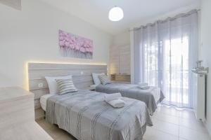 a bedroom with two beds and a window at Neos Marmaras Family Suite in Neos Marmaras