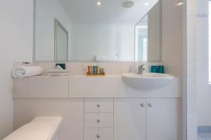 a white bathroom with a sink and a mirror at The Beach House At Bayside in Albany +47 photos
