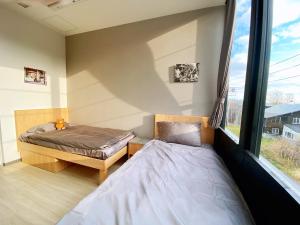 a bedroom with two beds and a window at Q FOX BLACK DIAMOND HOTEL in Niseko