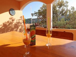 dos copas de vino sentadas en una mesa de madera en Peaceful Holiday House Senija, en Vela Luka