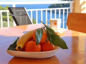 un bol de fruits avec une banane et des oranges sur une table dans l'établissement Peaceful Holiday House Senija, à Vela Luka