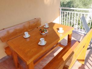 - une table en bois avec des tasses et un bol de fruits dans l'établissement Peaceful Holiday House Senija, à Vela Luka
