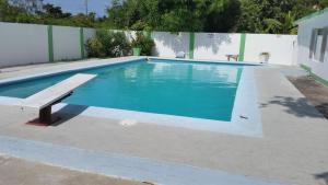 una piscina con un banco al lado en Villa Donna Inn en Montego Bay