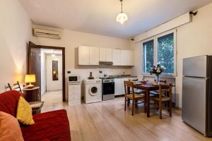 een keuken en een woonkamer met een tafel en een koelkast bij Via Mocenigo in Venetië-Lido