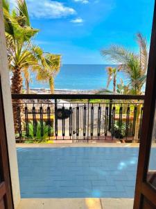 uma vista para o oceano a partir de uma varanda com um portão em PRAIOLA BEACH HOUSE em Pozzillo