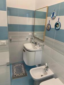 uma casa de banho com um WC, um lavatório e um espelho. em PRAIOLA BEACH HOUSE em Pozzillo