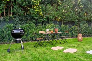 un barbecue e un tavolo con sedie in un cortile di Villetta Padova a Padova