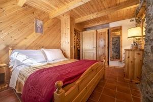 a bedroom with a bed in a wooden room at Chalet indipendente Mas Tarlenta nel Parco Nazionale dello Stelvio in Peio