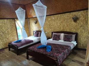 a bedroom with two beds with curtains and a bench at Activities Resort in Ko Yao Yai