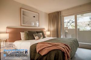 a bedroom with a large bed and a window at Wintergreen 3 in Thredbo