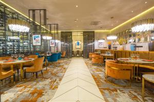 a dining room with tables and chairs and a restaurant at Novotel Ulaanbaatar in Ulaanbaatar