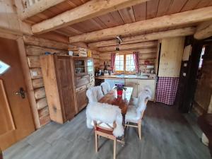 eine Küche mit einem Tisch und Stühlen in einer Hütte in der Unterkunft Naturstammhaus, Blockhaus in Klagenfurt am Wörthersee