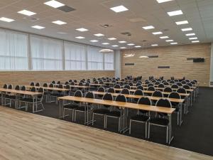 une salle de conférences vide avec des tables et des chaises dans l'établissement Kvåstunet, à Lyngdal