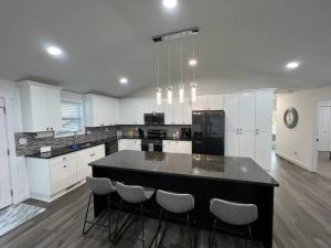 a large kitchen with a black island in the middle at Modern Home at Colonial College Park Atlanta in Atlanta