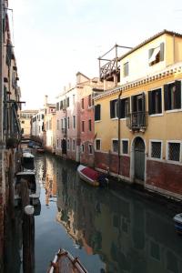 un canal con edificios y barcos en el agua en Erbe Canal View Private House, en Venecia