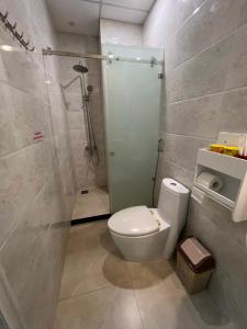La salle de bains est pourvue de toilettes et d'une douche en verre. dans l'établissement Khách Sạn Trung Anh 78 HAI BÀ TRƯNG BMT, à Buôn Ma Thuột