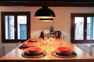 una cocina con una mesa con platos y copas de vino en Erbe Canal View Private House, en Venecia