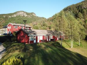 a red house in the middle of a mountain at Kvåstunet in Lyngdal