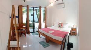 Corong Beach Resort في إل نيدو: غرفة نوم بسرير وطاولة ونافذة