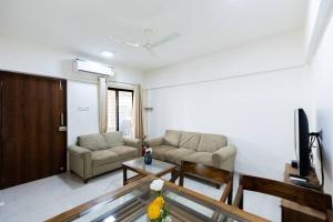 a living room with a couch and a tv at Lotus 3BHK by SoulStays in Dapoli