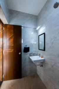a bathroom with a sink and a mirror at Lotus 3BHK by SoulStays in Dapoli