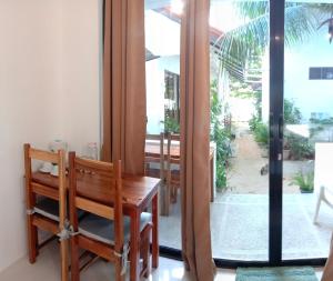 een eetkamer met een houten bank en een raam bij Corong Beach Resort in El Nido