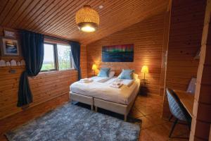 1 dormitorio con 1 cama en una habitación de madera en Farmhotel Efstidalur, en Laugarvatn
