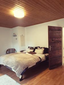 - une chambre avec un grand lit et un plafond en bois dans l'établissement Die Alm in Schöllbüchl, à St. Martin