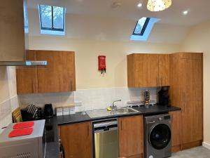 a kitchen with wooden cabinets and a sink and a dishwasher at Kilmory in Arisaig