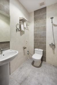 La salle de bains est pourvue de toilettes blanches et d'un lavabo. dans l'établissement Mirada Purple - Obhur, à Djeddah