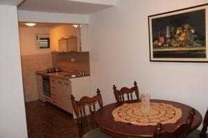 a kitchen with a table and chairs and a dining room at Apartmani Dragović in Sveti Stefan