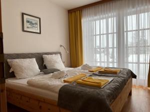 トゥルラッハー・ヘーエにあるMei Zeit Hüttendorfのベッドルーム1室(大型ベッド1台、タオル付)