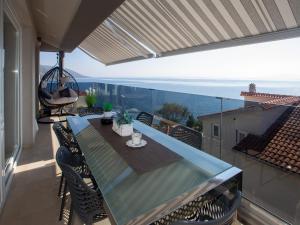 - une table à manger sur un balcon avec vue sur l'océan dans l'établissement Apartments Aqua, à Trogir
