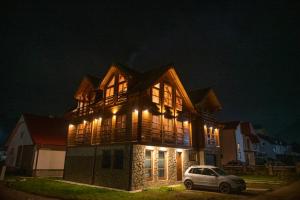 a house with a car parked in front of it at night at Mountain Boy chalet with sauna in Kolašin