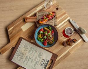 uma mesa com um prato de comida e um livro em Farsund Fjordhotel em Farsund