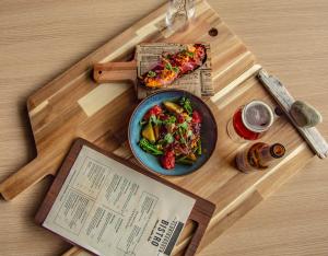 una mesa con un plato de comida y un libro en Farsund Fjordhotel, en Farsund