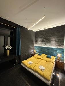 a bedroom with a large bed with yellow sheets and pillows at DarkHouse Versace Blue in Łódź
