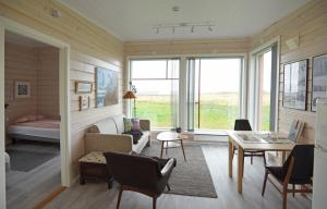 Ekkerøy Feriehus في فادسو: غرفة معيشة بألواح خشبية ونافذة كبيرة