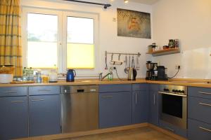 eine Küche mit blauen Schränken und einer Arbeitsplatte in der Unterkunft Ferienwohnung "Schwanenwiek" in Lubmin
