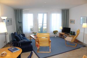 ein Wohnzimmer mit einem blauen Sofa und einem Tisch in der Unterkunft Ferienwohnung "Schwanenwiek" in Lubmin