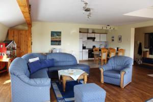 a living room with two blue chairs and a table at Ferienwohnung am Schloss in Ueckermünde