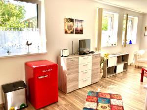 a living room with a red refrigerator and a tv at Ferienwohnung GreifZu Pröger in Greifswald