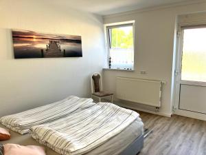 a bedroom with a bed and a painting on the wall at Ferienwohnung GreifZu Pröger in Greifswald