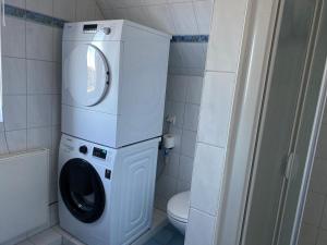 a washer and dryer in a bathroom with a toilet at Ferienwohnung Marina am Ryck in Greifswald