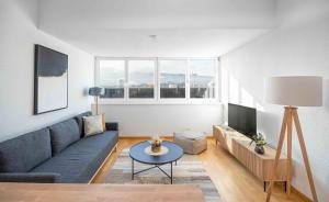 蘇黎世的住宿－Modern 3BDR Duplex with Skyroof in Trendy Zurich West，客厅配有蓝色的沙发和电视