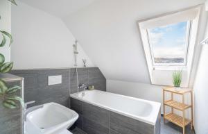 a white bath tub in a bathroom with a window at Modern 3BDR Duplex with Skyroof in Trendy Zurich West in Zurich