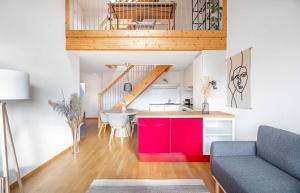 eine Küche und ein Wohnzimmer mit einem roten Schrank in der Unterkunft Modern 3BDR Duplex with Skyroof in Trendy Zurich West in Zürich